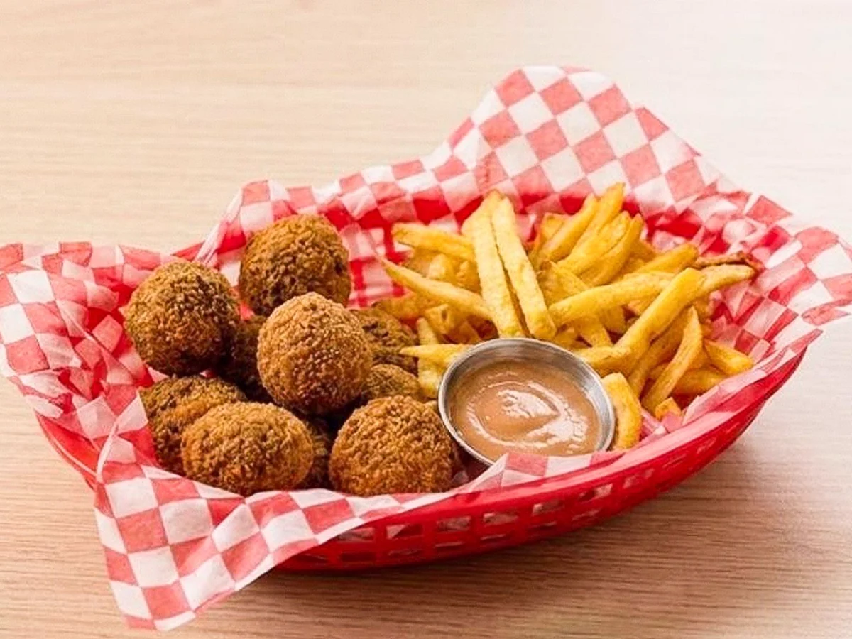 Nuggets dorados junto a papas fritas y salsa.